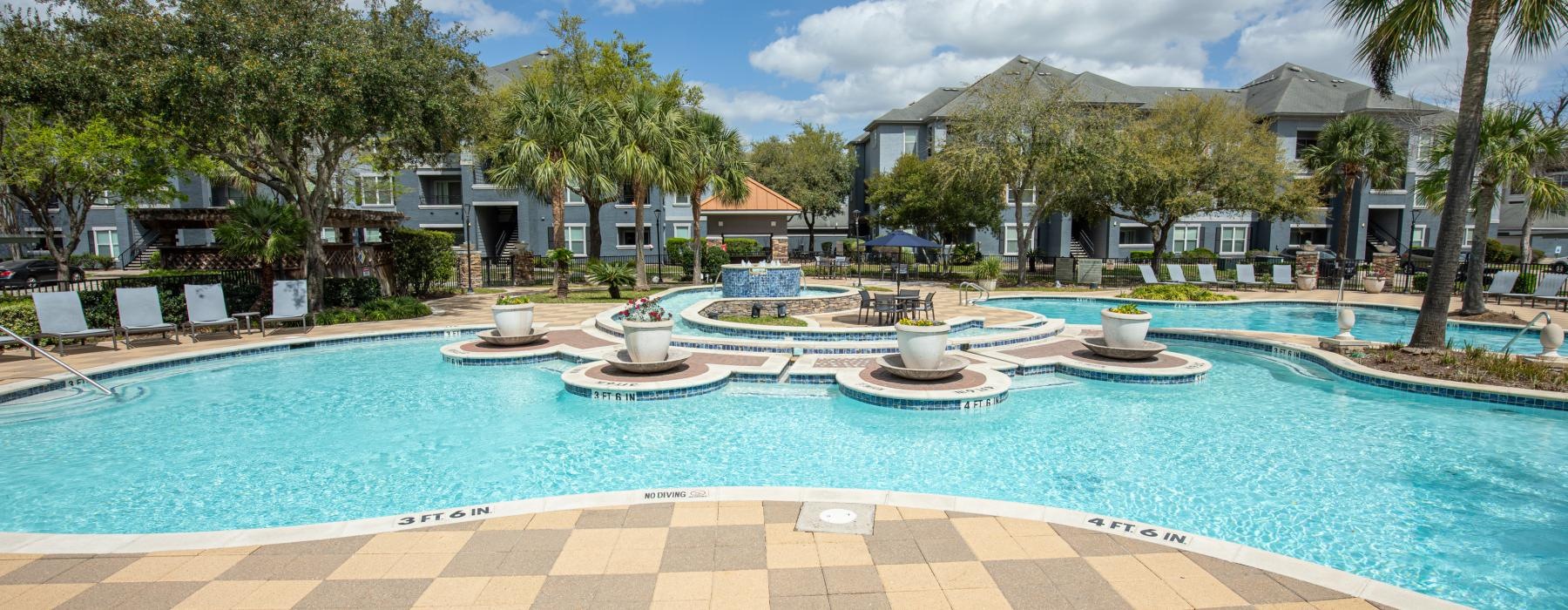 a pool with a deck and trees around it